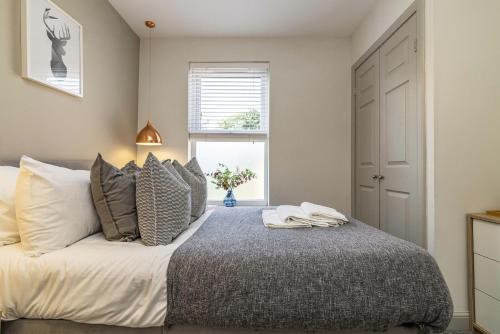 1 dormitorio con cama con almohadas y ventana en Stay @ Baker Street Derby en Derby