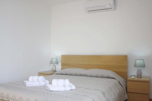a bedroom with a bed with white towels on it at Lugar dos Louros 2 in Estreito da Calheta