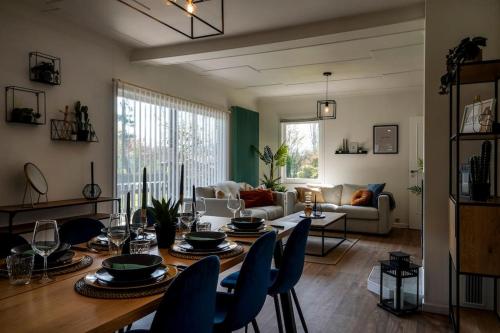 a living room with a table and chairs and a couch at Villa spacieuse et accueillante in Mons