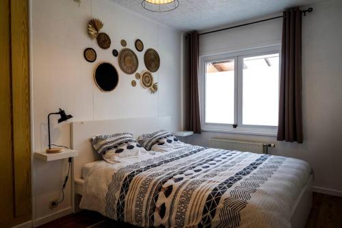 een slaapkamer met een bed met kussens en een raam bij Villa spacieuse et accueillante in Bergen