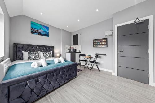 um quarto com uma cama grande e uma cozinha em Cozy Serviced Room in Feltham Heathrow London TW13 em Feltham
