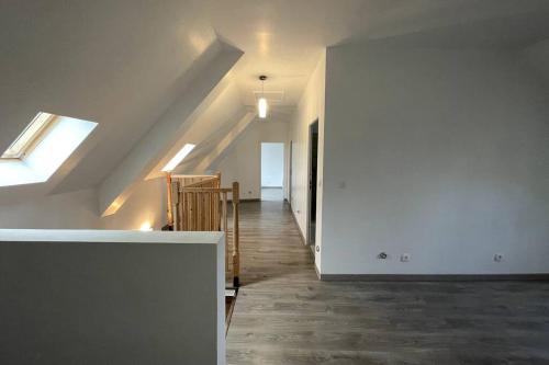 an attic room with a staircase and a room with a window at Maison spacieuse de Lila avec 3 places de parkings in Crèvecoeur-le-Grand