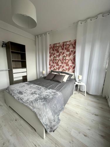 Schlafzimmer mit einem großen Bett mit einem rosa Kopfteil in der Unterkunft Appartement 6/8 pers Plage à 10min NETFLIX in Dunkerque