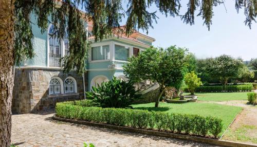 uma casa azul com uma árvore em frente em Torres da Vila em Anadia