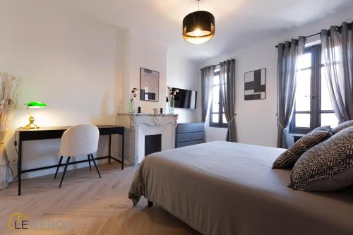a bedroom with a bed and a desk and a chair at The Neroli Elegant and spacious ideally located in Grasse