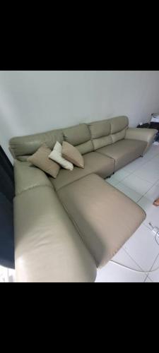 a white couch with two pillows on it at P'RESIDENSI HOLIDAY APARTMENT in Puchong