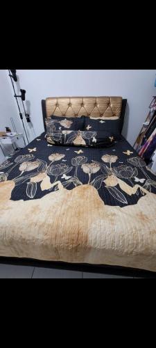 a bed with a black and white bedspread and pillows at P'RESIDENSI HOLIDAY APARTMENT in Puchong