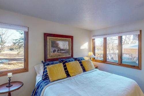een slaapkamer met een bed en 2 ramen bij Nanacitas Casita in Greeley
