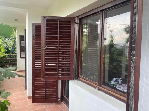 a window with wooden shutters on a house at Hostel Drenak in Gornje Rataje