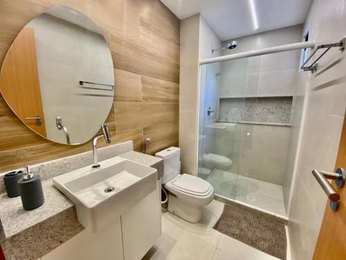 a bathroom with a toilet and a sink and a mirror at Flat luxo torre 07 Eco Resort Praia dos Carneiros in Tamandaré