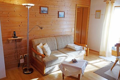 a living room with a couch and a lamp at Ferienwohnungen mit Bergblick in Inzell