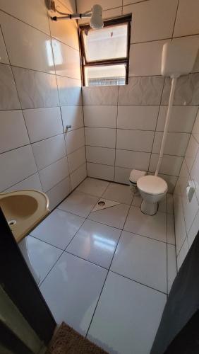 a small bathroom with a toilet and a sink at Hotel e Restaurante do Baixinho in Planalto