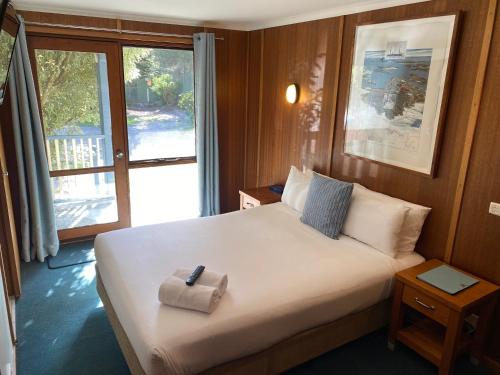 1 dormitorio con 1 cama con mando a distancia en Point Lonsdale Guest House, en Point Lonsdale