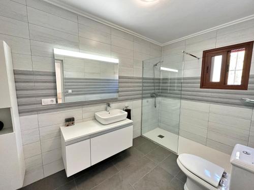 a bathroom with a sink and a toilet and a mirror at Villa Paraiso in Jávea