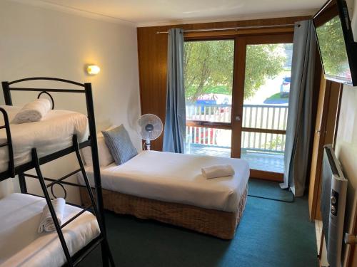 a bedroom with two bunk beds and a balcony at Point Lonsdale Guest House in Point Lonsdale