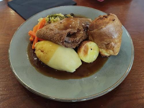 a plate of food with meat and vegetables on a table at Keer Side Lodge, Luxury lodge with private hot tub at Pine Lake Resort in Carnforth