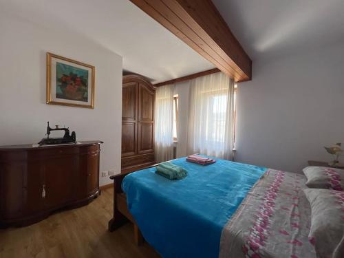 a bedroom with a blue bed and a dresser at Conveniente, tranquilla e accogliente con park in Belluno
