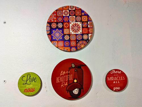 a wall with four stickers on a wall at Awaara Backpackers Hostel, Alibag in Alibag