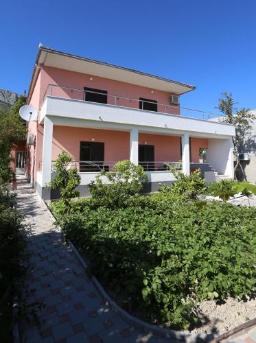 a pink house with bushes in front of it at Apartment Fila i Jure in Solin