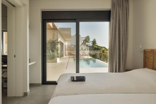 een slaapkamer met een bed en uitzicht op een zwembad bij Villa Mare Incredible 3 bed villa private pool in Paleros
