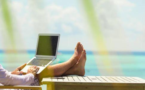 a person with their feet up on a table with a laptop at The George Hotel in Georgetown