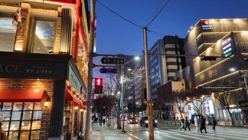 a busy city street at night with a red traffic light at For you House in Daegu