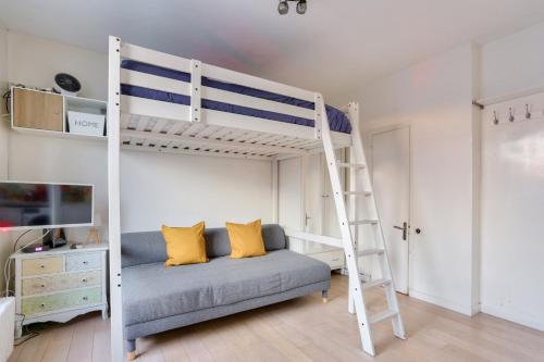 ein Schlafzimmer mit einem Etagenbett und einem Sofa in der Unterkunft Studio - Appartement Quartier Tour Eiffel 3 in Paris