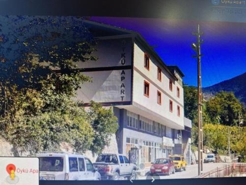 un edificio con coches estacionados frente a él en SEYİTLER KÖYÜ ARTVİN MERKEZ en Artvin