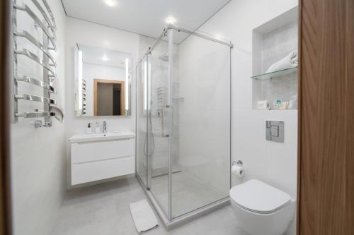 a bathroom with a shower and a toilet and a sink at Ambassador Orient in Bishkek