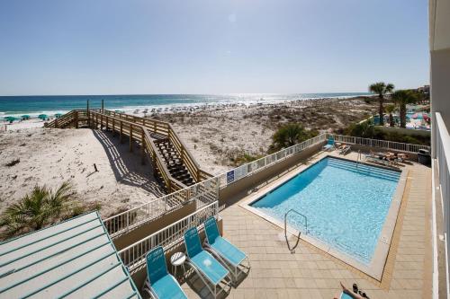 - une piscine avec des chaises à côté d'une plage dans l'établissement Gulf Dunes 215: Cozy 2 bedroom/2 bath with BONUS BUNK ROOM, à Fort Walton Beach