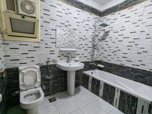 a bathroom with a sink and a toilet and a bath tub at Gem & Pyramids Front in Cairo