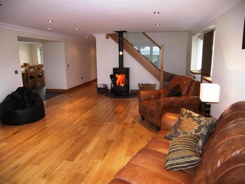 a living room with a couch and a fireplace at Criffel Glen in Dumfries