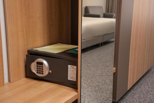 a door to a room with a microwave and a bed at Ambassador Orient in Bishkek