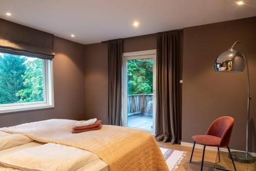 um quarto com uma cama, uma janela e uma cadeira em Cozy House em Oslo