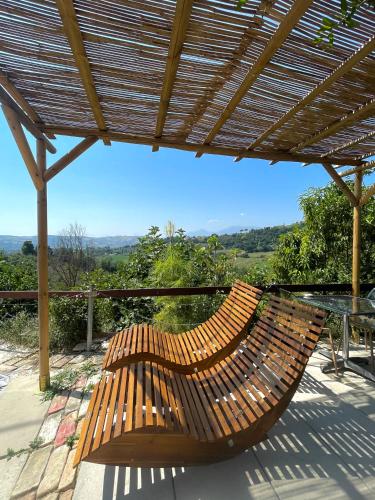 a wooden bench sitting on a patio with a table at Glamping Lost in Monsampolo del Tronto
