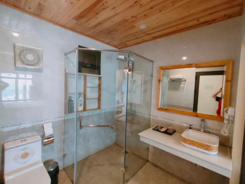 a bathroom with a glass shower and a sink at SaPa Retreat Condotel in Sa Pa