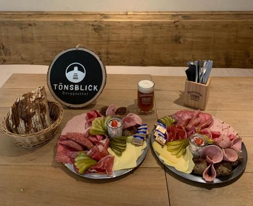 two plates of food sitting on a wooden table at Berggasthof Tönsblick in Oerlinghausen