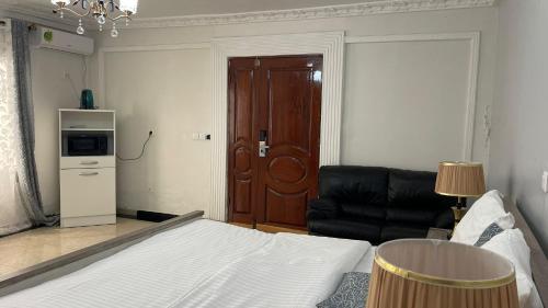 a bedroom with a bed and a chair and a door at PEACE GUEST HOUSE in Yaoundé