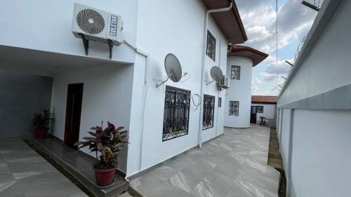 a hallway of a white building with pictures on the walls at PEACE GUEST HOUSE in Yaoundé