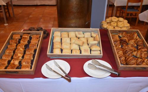 a table with trays of pastries and plates of food at SNÖ Vall de Boí in Pla de l'Ermita