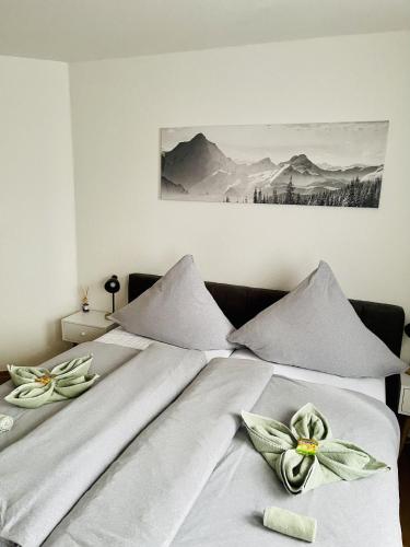 a bed with white sheets with flowers on it at Ferienwohnungen Anne in Schönebeck