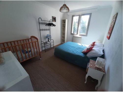 een slaapkamer met een bed en een wieg erin bij Maison confort et repos in Crecy la Chapelle