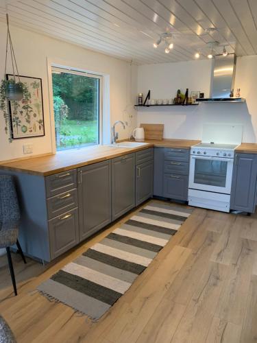 a kitchen with gray cabinets and a white stove at Huset ved søen tæt på Herning og MCH og boxen 90 m2 in Sunds
