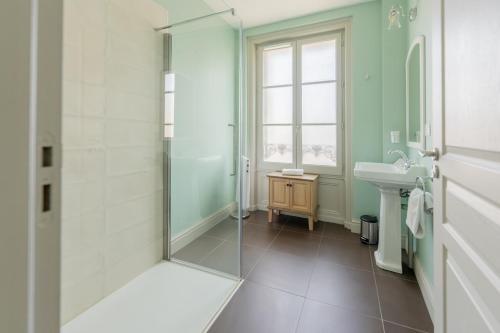 W łazience znajduje się szklana kabina prysznicowa i umywalka. w obiekcie Hotel Heritage w mieście Cognac