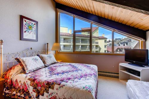a bedroom with a bed and a large window at The Plaza Condominiums by Crested Butte Mountain Resort in Mount Crested Butte