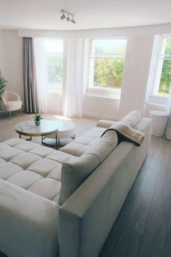 a living room with a white couch and two tables at Brighton Apartment by Pier in Brighton & Hove