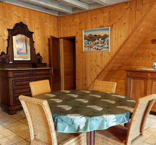 une salle à manger avec une table, des chaises et un miroir dans l'établissement Moulin de Frely, à Pouzauges