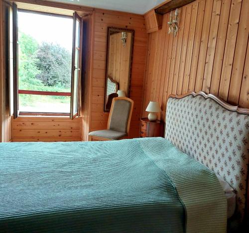 een slaapkamer met een bed, een stoel en een raam bij Moulin de Frely in Pouzauges