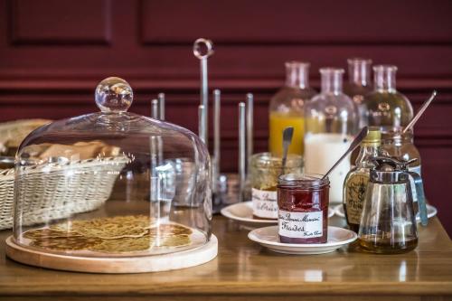 een tafel met een glazen pot met eten en flessen bij Hotel Heritage in Cognac