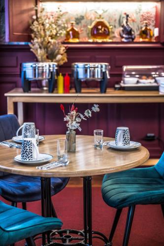 een houten tafel met stoelen en borden erop bij Hotel Heritage in Cognac